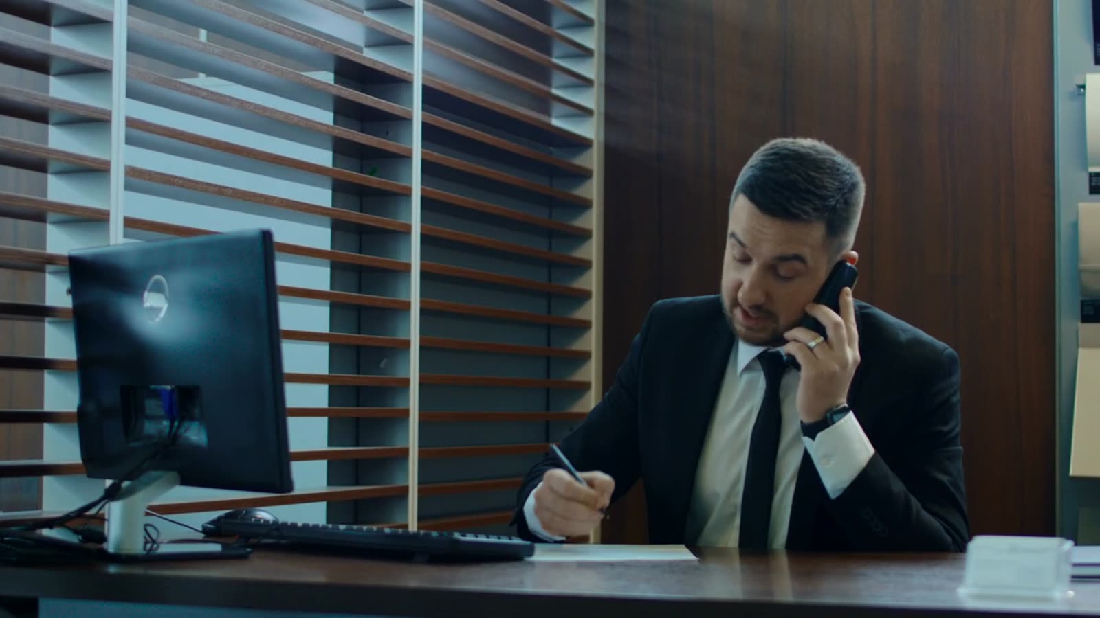 Estimator on a phone call at his desk, taking notes