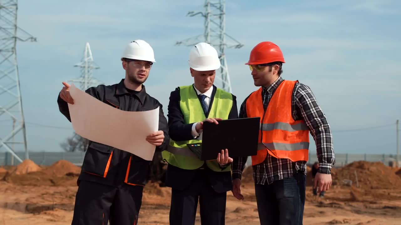 Estimators reviewing plans and pricing on a laptop at a job site